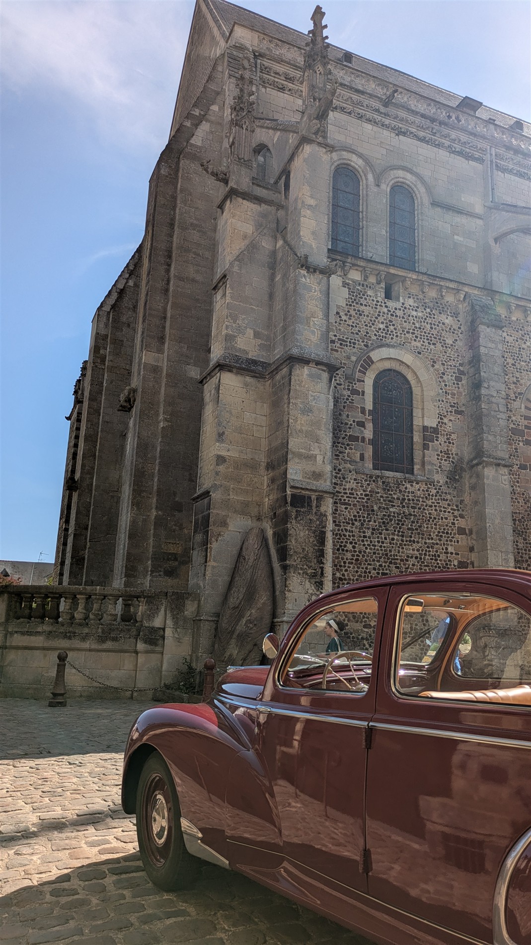 Peugeot 203 rouge au pied du patrimoine manceau